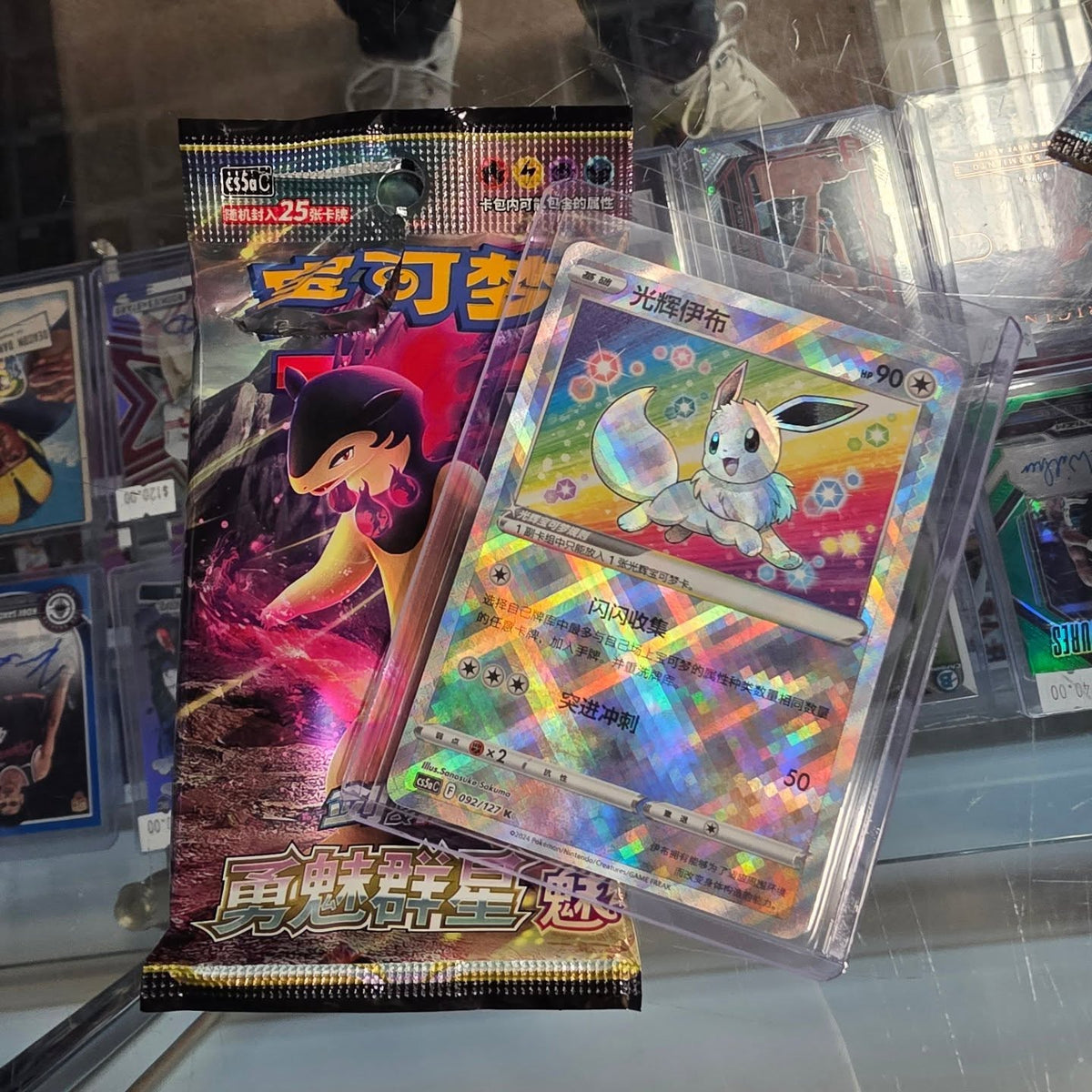 A Chinese Pokémon booster pack and the holo card pulled from it, shown on the counter at Cards2Go